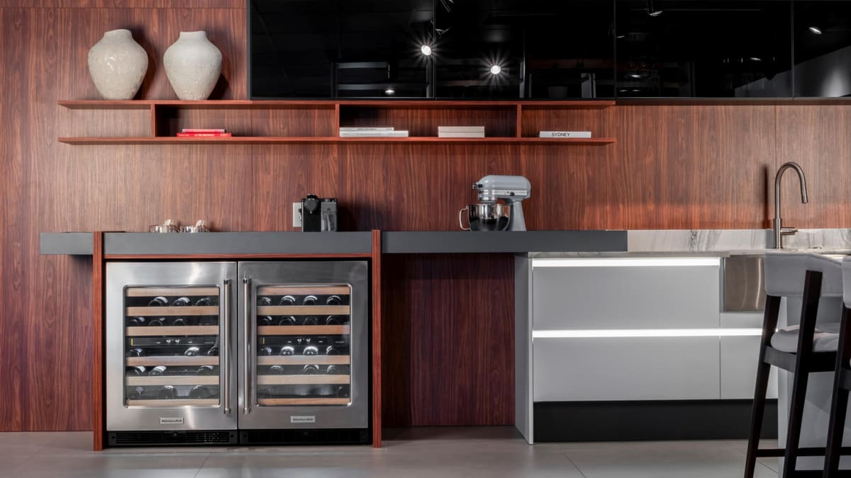 Walnut bar wall with twin wine coolers, floating shelves and a dark countertop