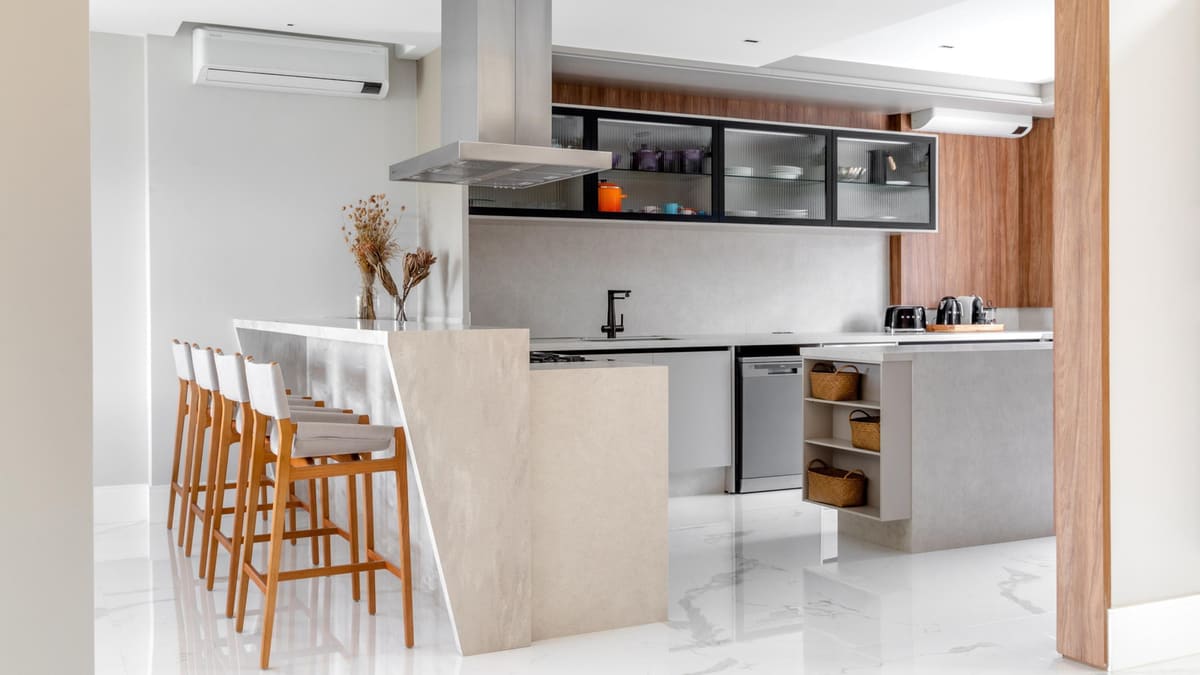 Kitchen with a stone waterfall counter, wood bar stools and black-framed glass wall cabinets