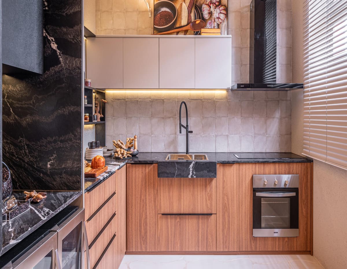 Wood kitchen with a black stone countertop, handmade tiles and a farmhouse sink