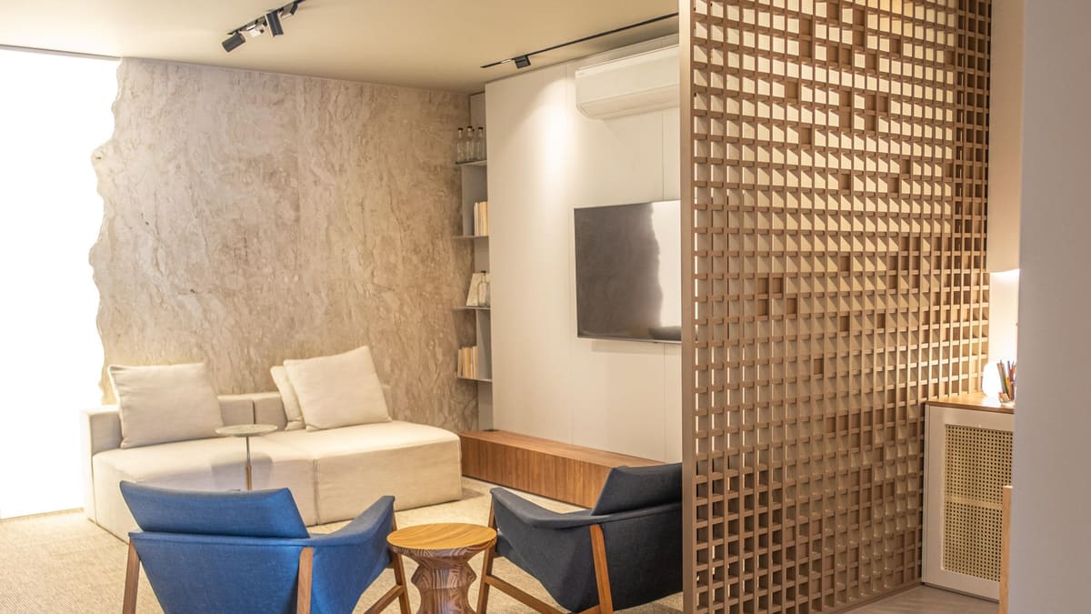 Living room beside a geometric wood screen and a textured stone wall